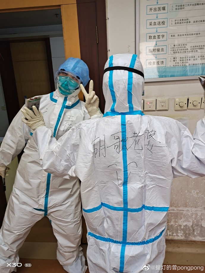 武漢第一線防疫人員慶祝又有病患出院，曬出自己身著防護衣的照片，背後驚見「胡歌老婆」四個大字。 圖：取自胡歌微博