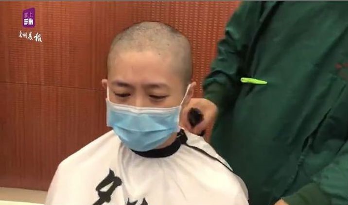 女性醫護人員剃去長髮，神情哀傷。 圖:翻攝自微博