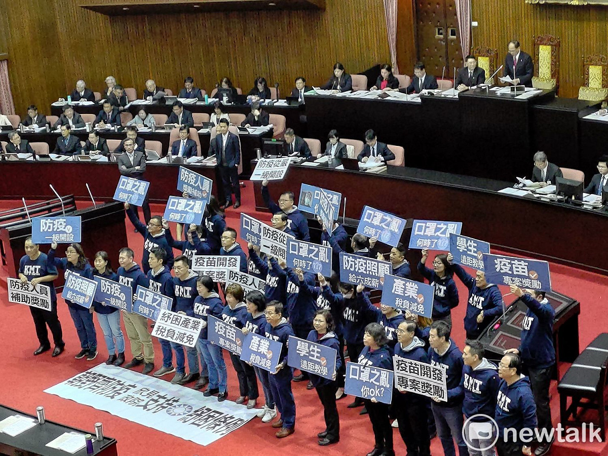 國民黨團舉牌，呼籲行政院支持國民黨版本的紓困條例草案。 圖：黃建豪/攝