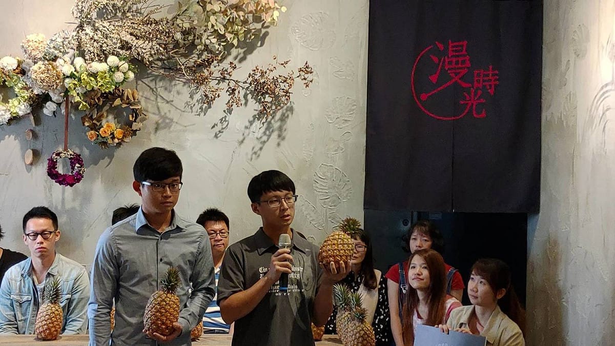 屏東農業大學青年農民涂焜棠(右)與涂翔凱（左）介紹金鑽鳳梨特色是不咬舌頭與酸甜新鮮像熱戀 圖/黃耀寬提供