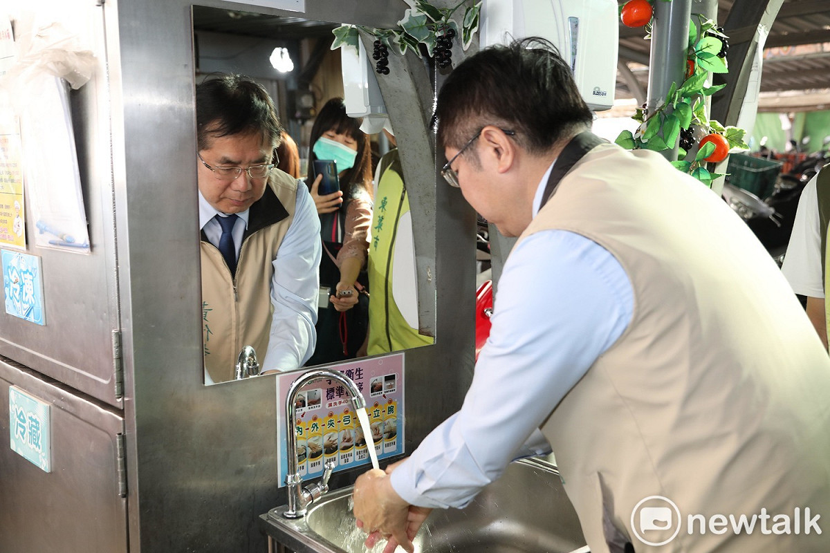黃偉哲在菜市場示範正確洗手方法。 圖：黃博郎／攝