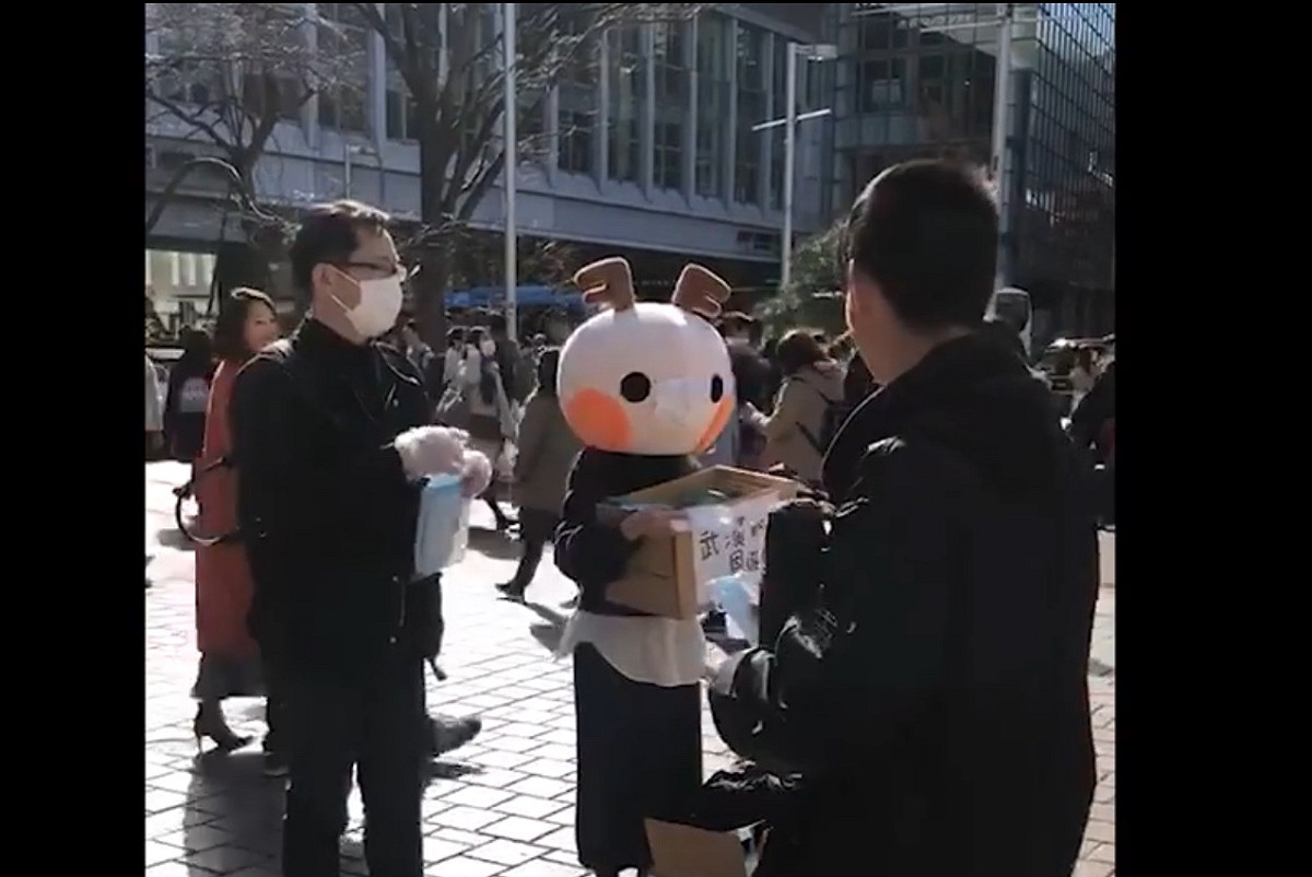中國人女網紅在數名中國男性協助下在東京街頭發口罩，說是對日本的報恩，三天就在微博獲得二萬次以上點閱。 圖：攝自微博