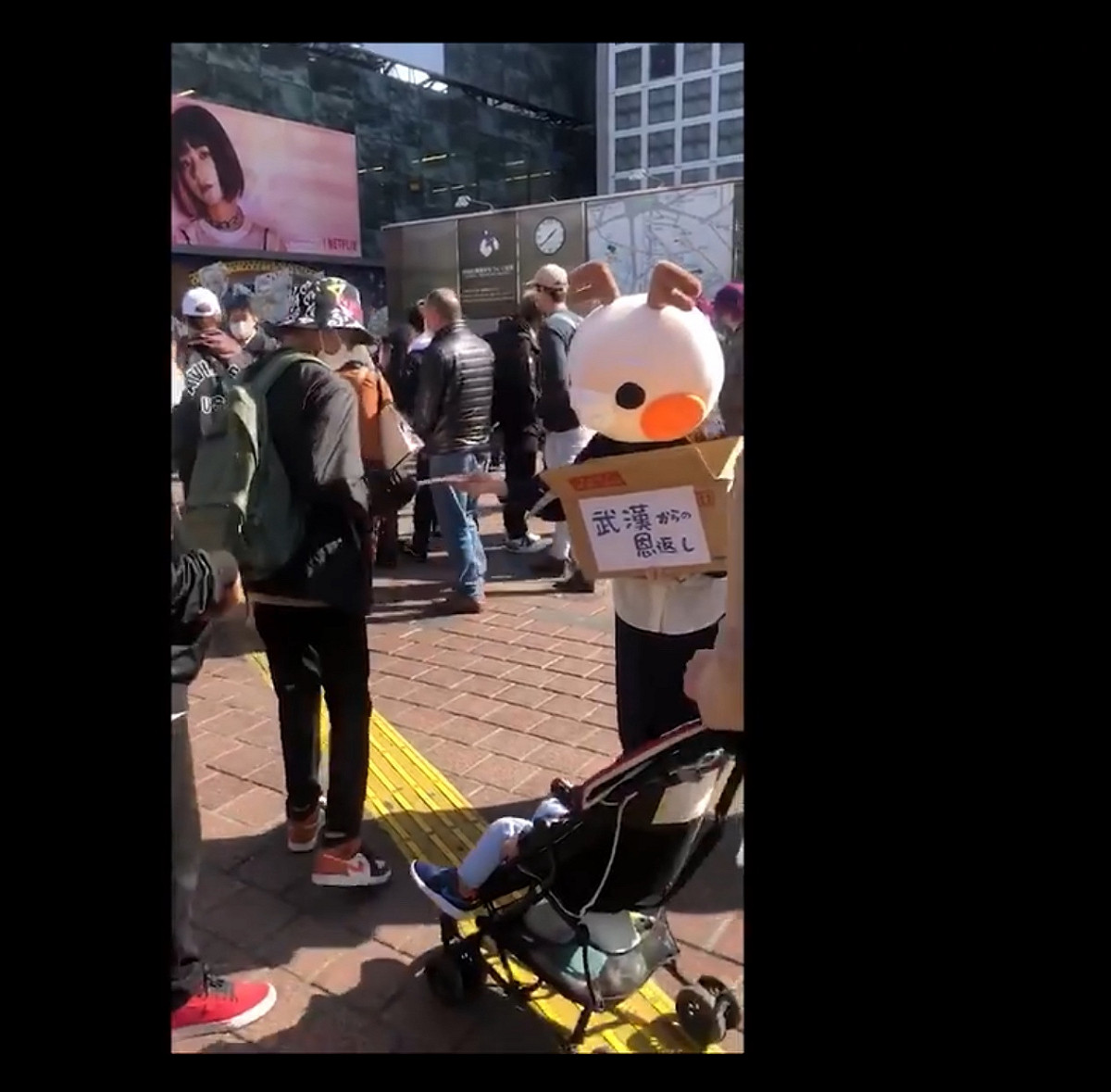 中國人女網紅在數名中國男性協助下在東京街頭發口罩，說是對日本的報恩，三天就在微博獲得二萬次以上點閱。 圖：攝自微博