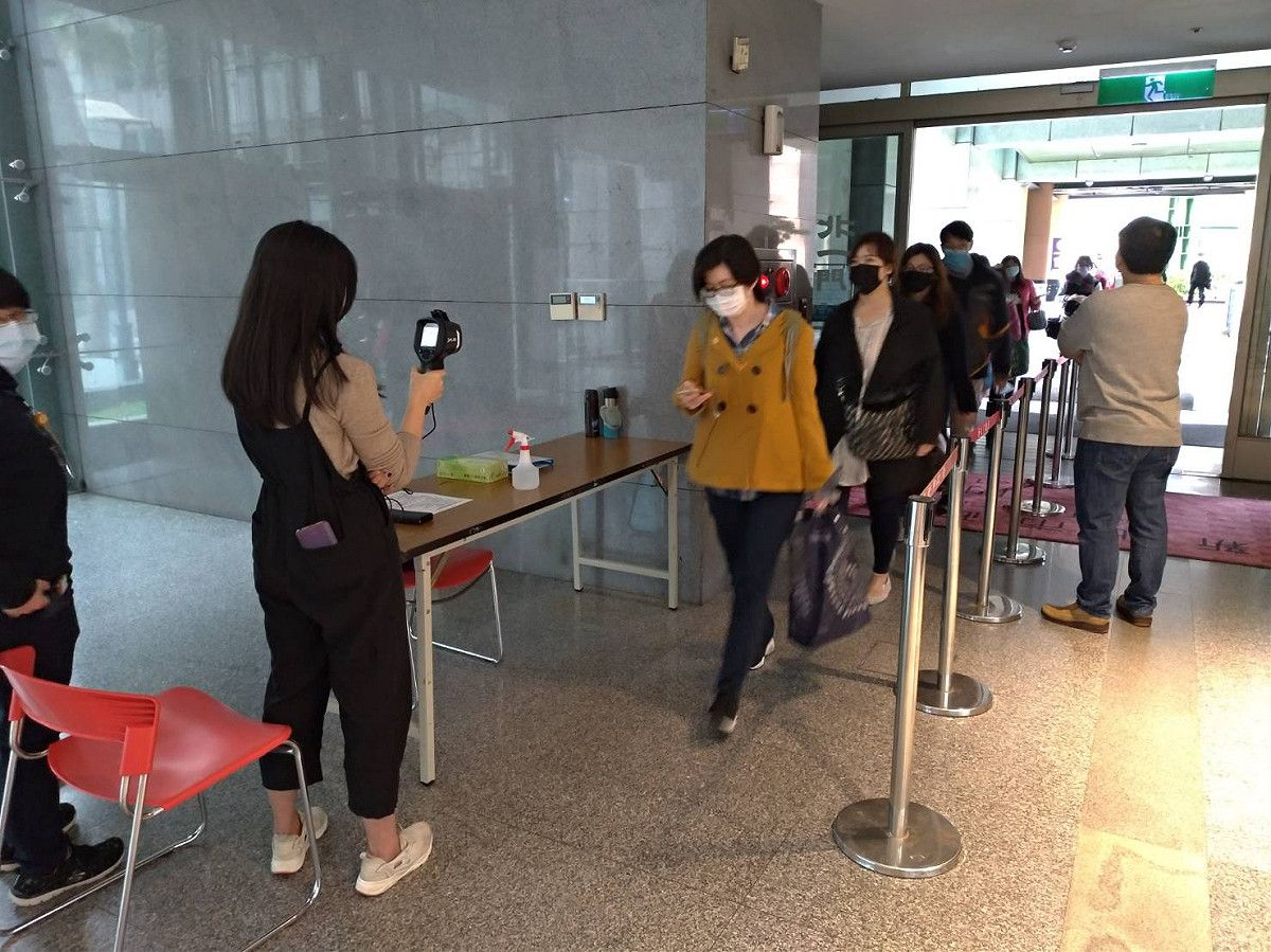 新北市府市政大樓自今天起，員工和民眾進出都必須先量體溫。 圖：王峻昌／攝