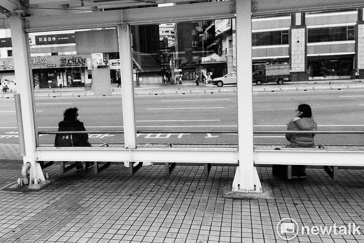 兩位民眾在台北車站等公車時，刻意拉開距離。 圖：張良一/攝