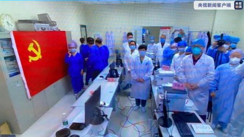 另一端，醫院內部醫護人員放下工作進行入黨儀式，旁邊掛著一幅中國共產黨黨旗。 圖：截自央視新聞