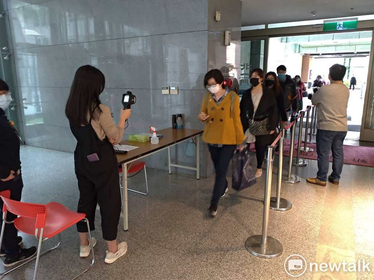 新北市府市政大樓自今天起，員工和民眾進出都必須先量體溫。 圖：王峻昌／攝