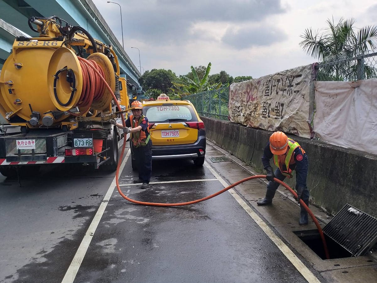 新莊區清潔隊員加班出勤挖除水溝水肥，並以清溝車清洗水溝。 圖：新北市環保局提供