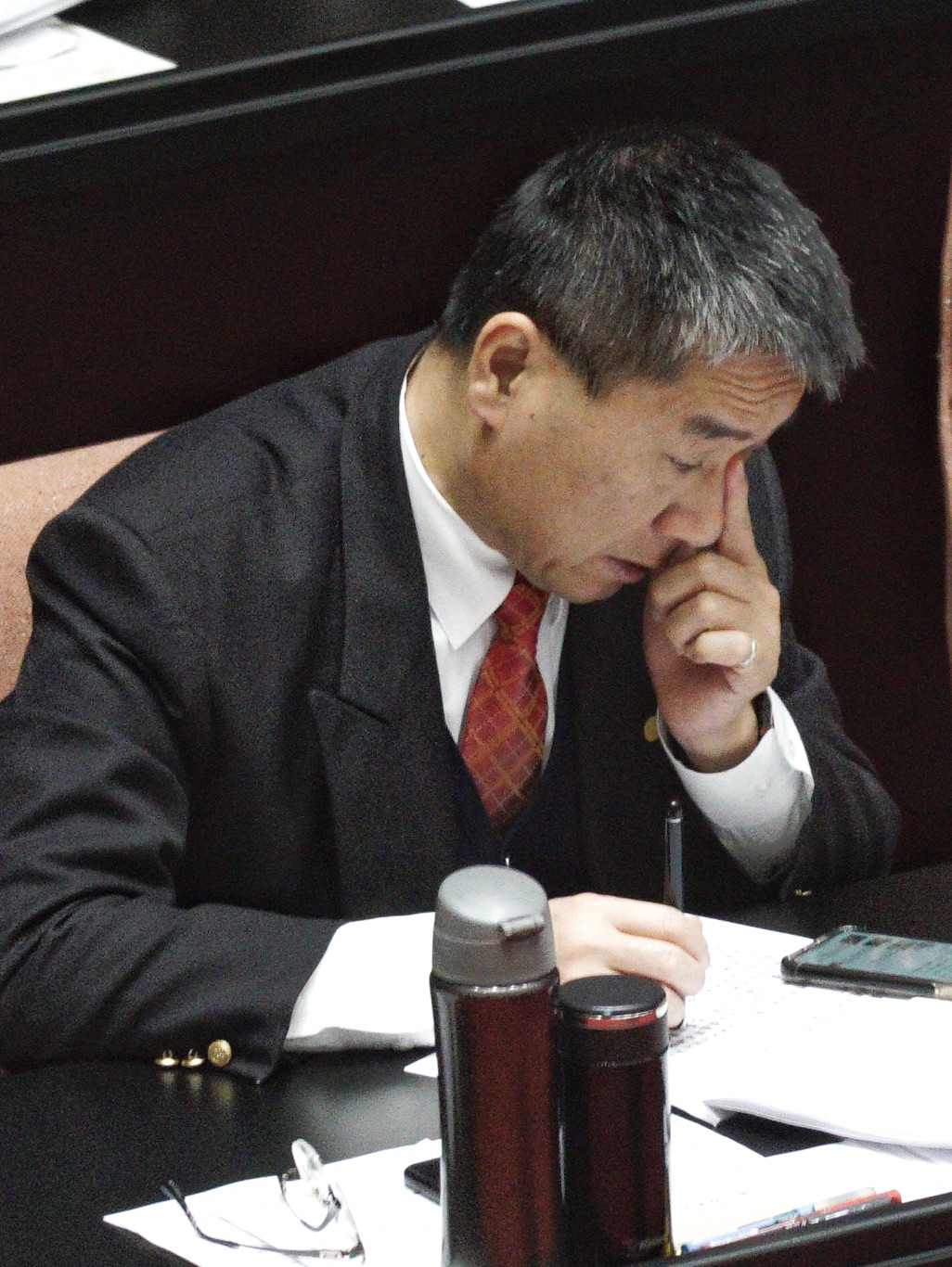 內政部長徐國勇一邊閱讀文件，一邊用手揉鼻子，神情若有所思。 圖：張良一/攝