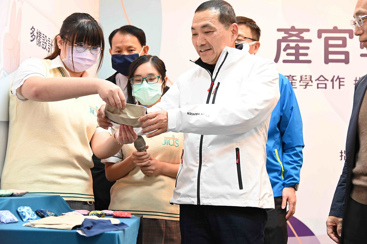 新北市長侯友宜現場試用學生做的口罩套。  圖：新北市教育局提供
