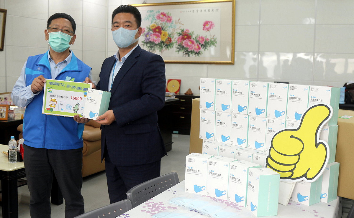 吳榕峯(左)接受艾多美公司捐贈的兒童口罩。 圖：高雄市教育局/提供