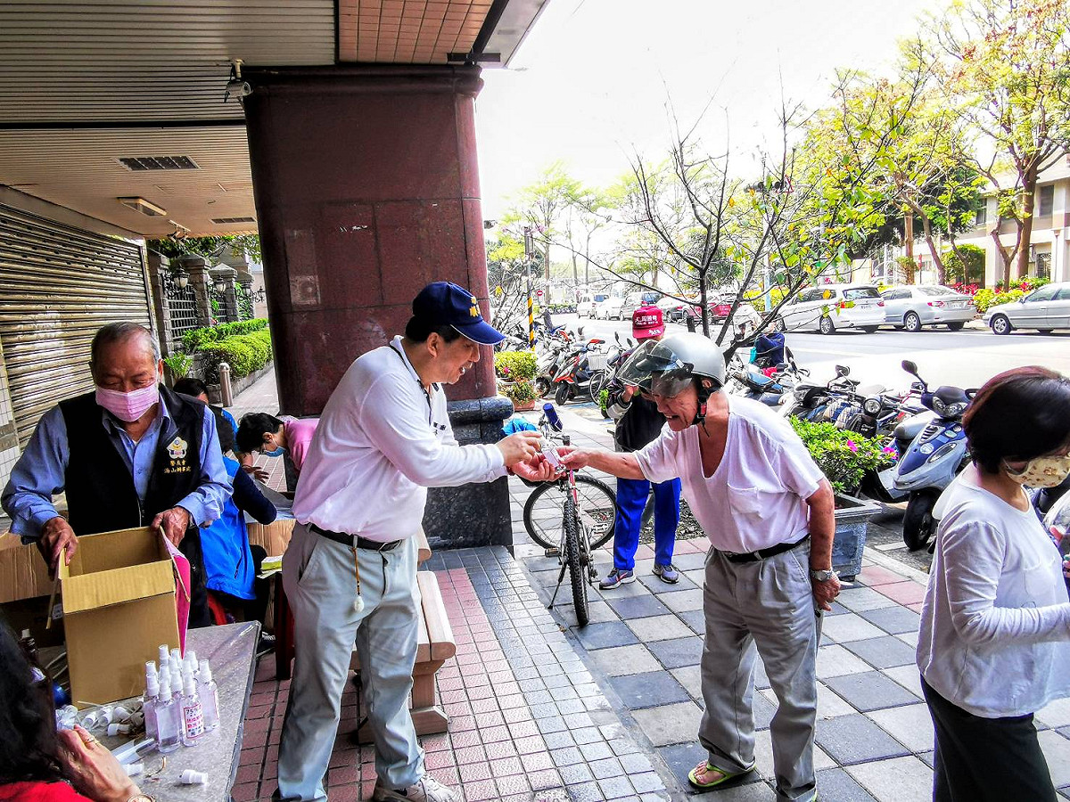 新北市議員周勝考（左二戴帽者）今早在服務處分送酒精。 圖：周勝考服務處提供