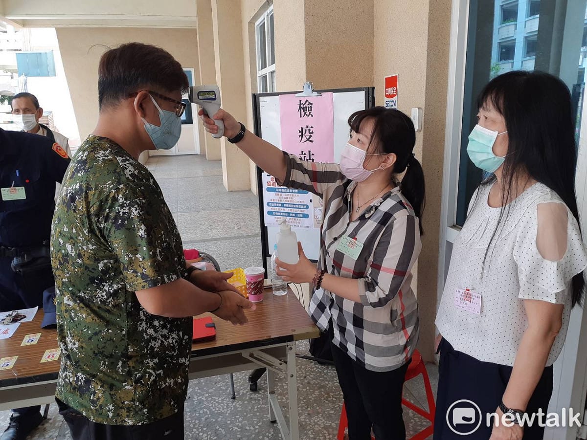 嘉義市義教里里長今天舉行補選，選民進入投開票所前必須經過檢疫，右為前往視察的東區區長田文珍。 圖：蔡坤龍/攝
