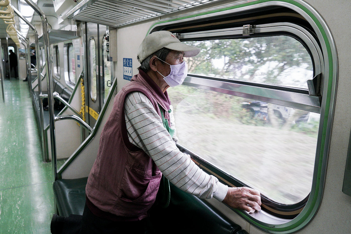 一位阿伯在火車上凝視著窗外風景。 圖：張良一/攝