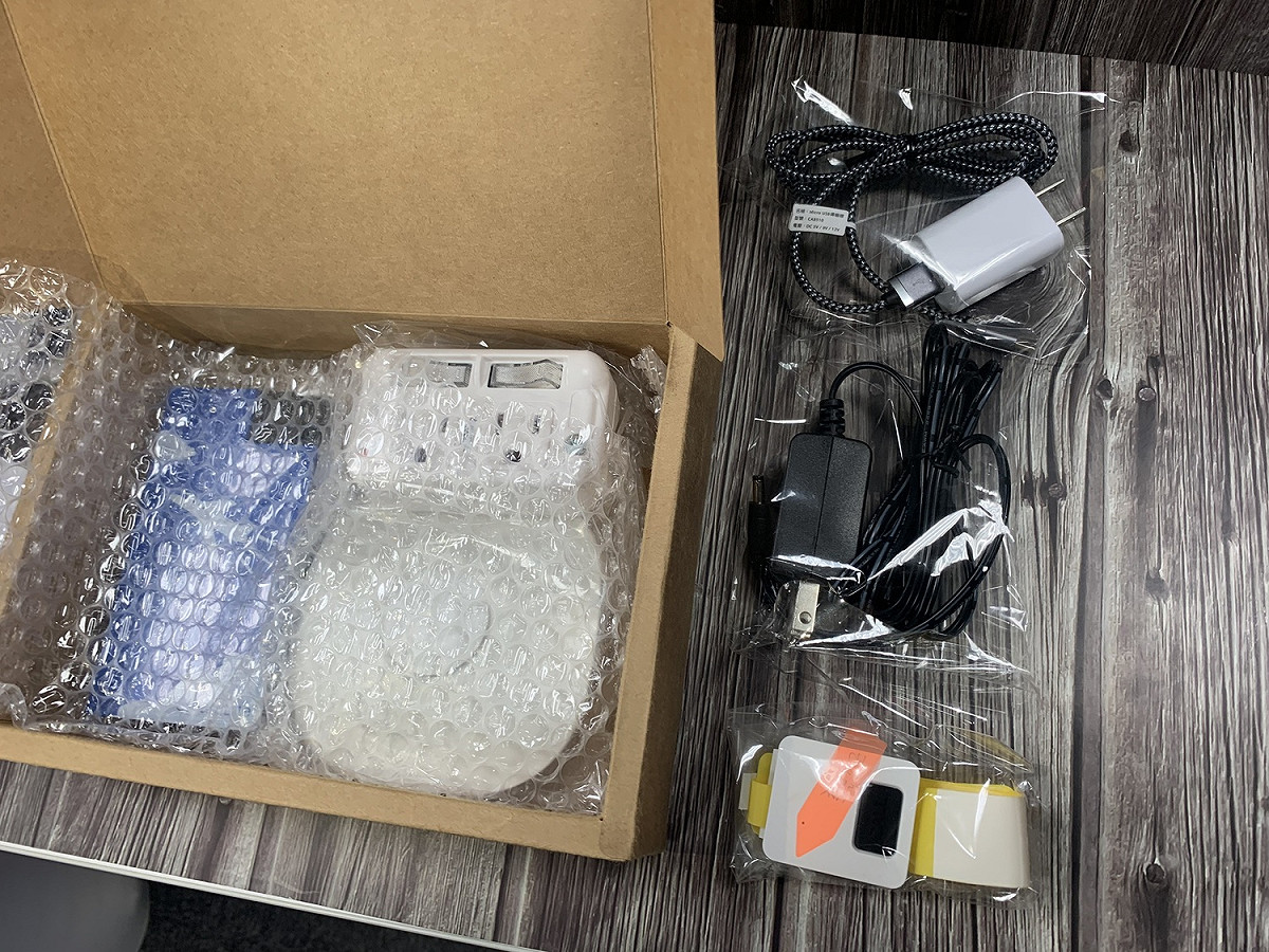 智慧離家警報器(盒內白色圓形)與闔家守護環(右前)設備陳列。 圖／黃耀寬提供