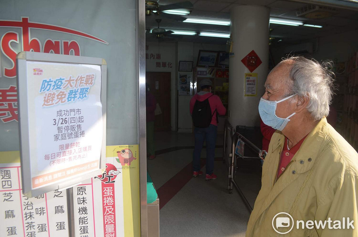 嘉義市福義軒成功門市突然宣佈今起停賣家庭號蛋捲，一名消費者看著告示牌久久不語。 圖：蔡坤龍/攝