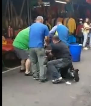 廖姓攤販先動手後遭管理員、其他攤販等四名男子打倒在地。 圖：翻攝自黑色豪門企業