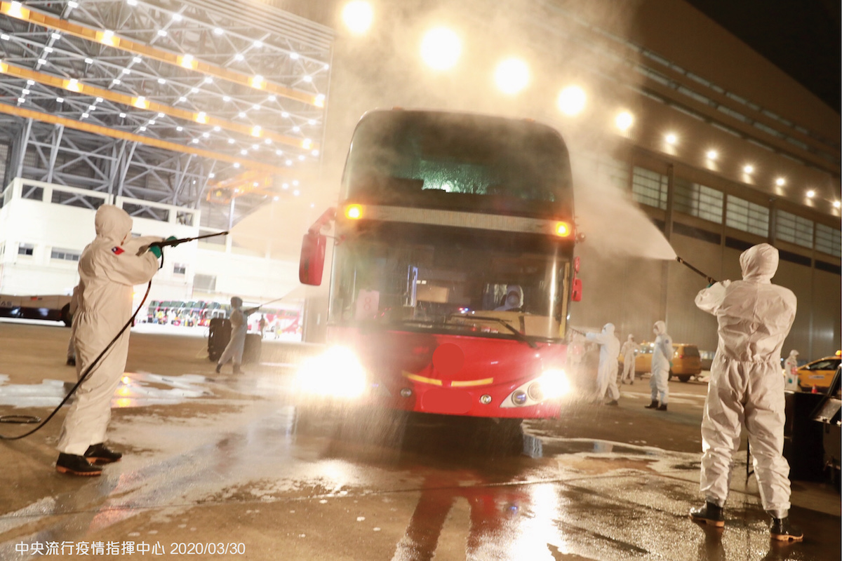 專車乘載返台國人前往檢疫所進行14天集中檢疫，化學兵對所有的車輛、作業機具、以及機棚地面進行全面消毒。 圖：中央流行疫情指揮中心／提供