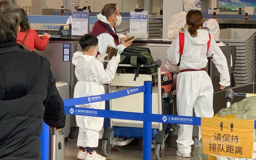 第2班湖北類包機30日晚間起飛，200多名乘客下午已辦理登機。圖為穿著自備防護衣的一家人。 圖：中央社