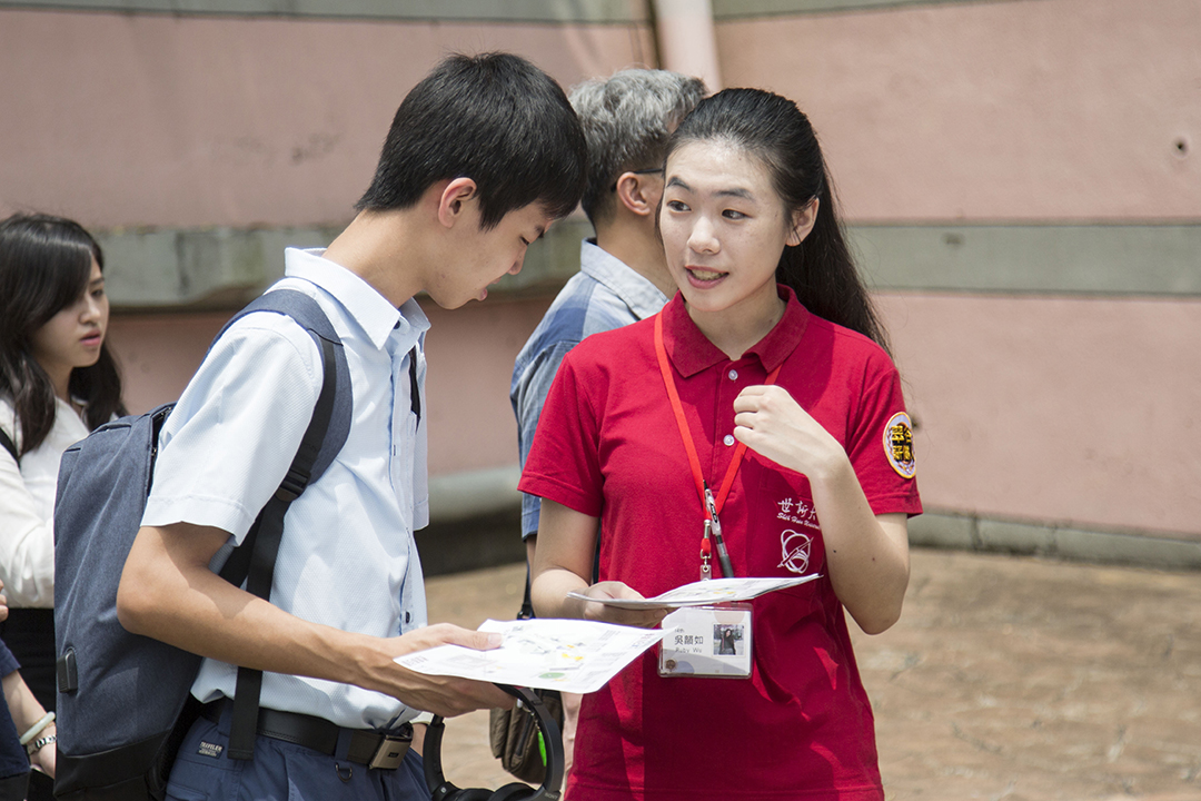 世新大學安排親善大使翠谷薪傳人（穿紅衣者），在校內協助指引考場路線、為考生服務。 圖／世新大學提供