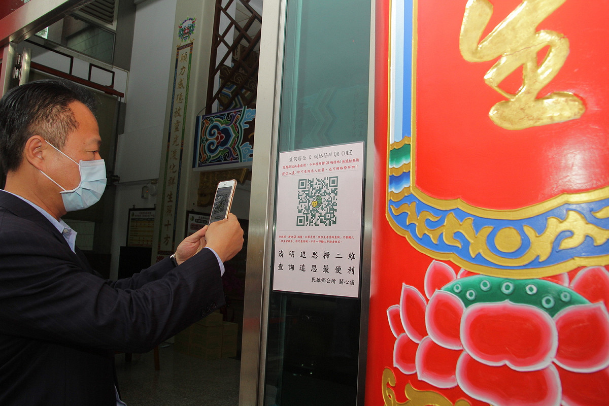 嘉義縣民雄鄉公所在納骨堂外設有QR Code，方便民眾網路祭拜，縣長翁章梁現場操作。 圖：嘉義縣政府/提供
