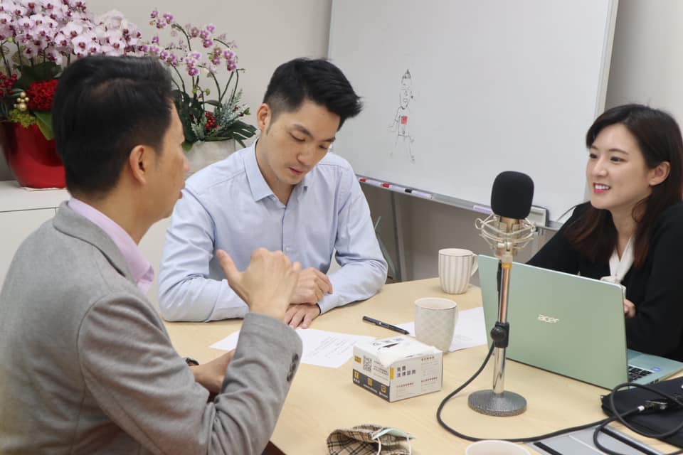 這張照片則看到增加了一名男子，桌上含有一支麥克風。 圖：翻攝自蔣萬安臉書