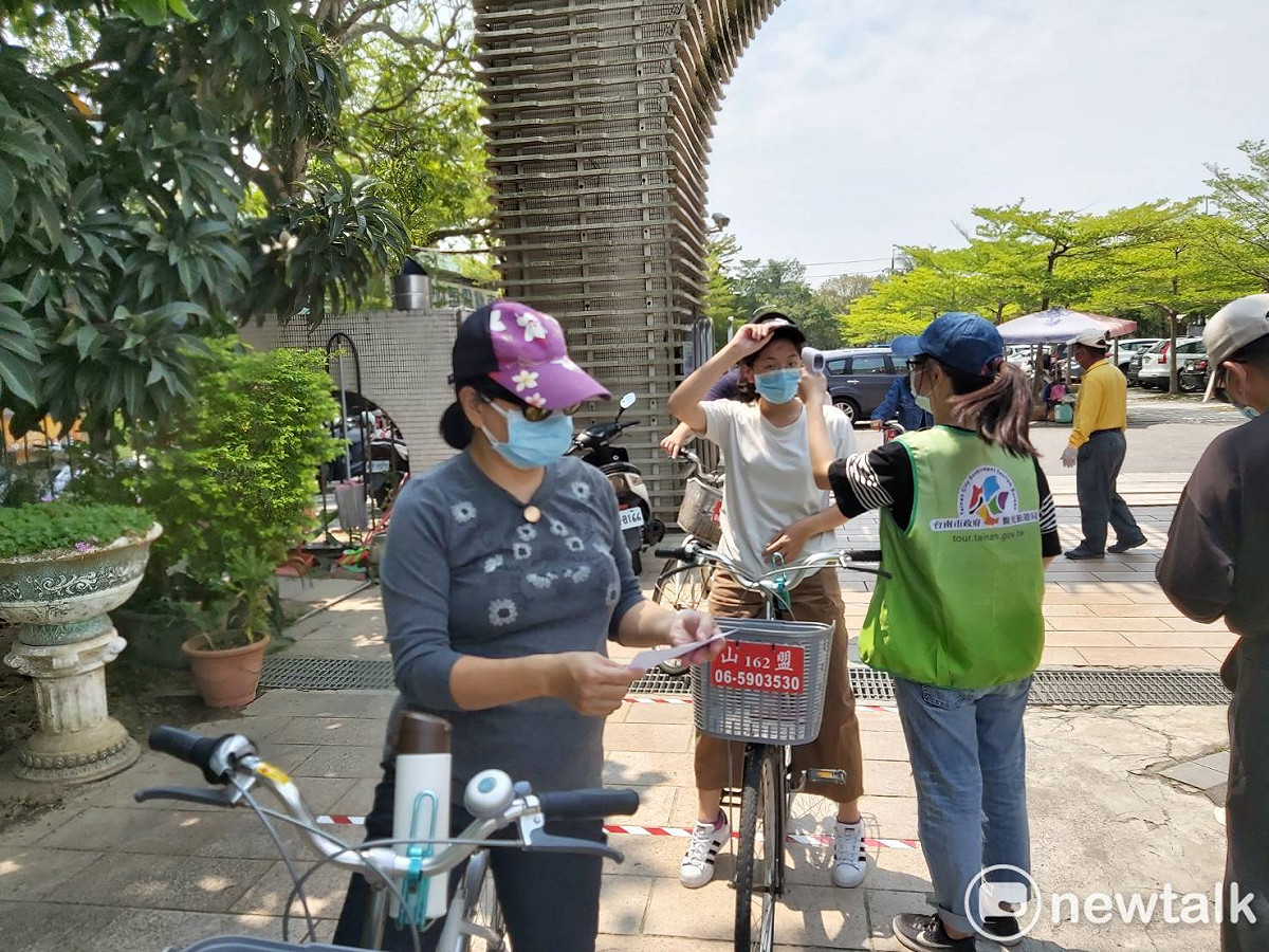 服務人員在虎頭埤風景區入口為遊客量體溫，並宣導防疫措施。 圖：台南市政府提供