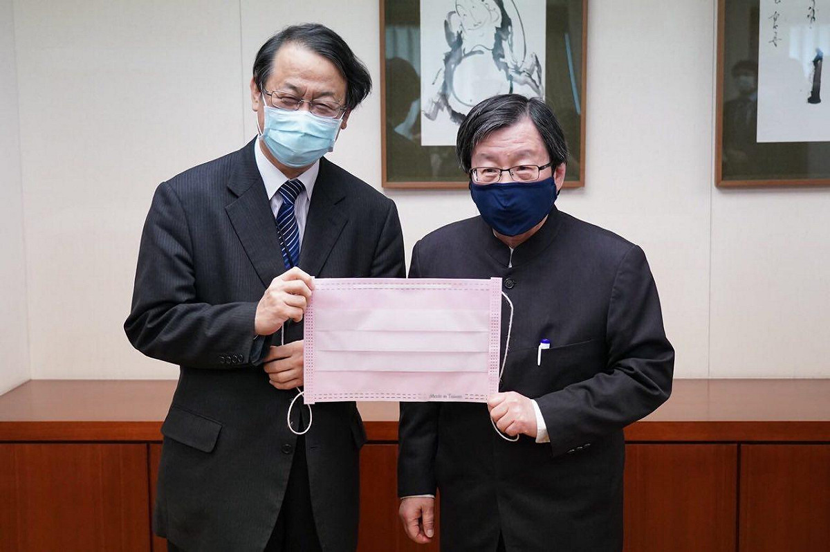 臺灣日本關係協會會長邱義仁（右）與交流協會台北事務所泉裕泰代表持粉紅道具口罩合影留念。 圖：外交部提供