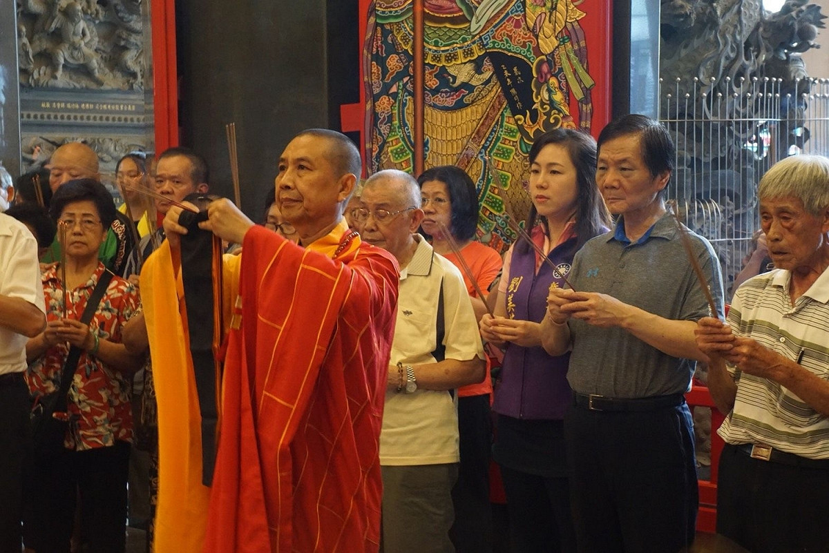劉炳偉 (右二)擔任板橋妙雲宮主委，與女兒劉美芳 (右三)長期從事公益及宗教活動，圖為妙雲宮為中低收入戶免費點光明燈。 圖：板橋妙雲宮提供