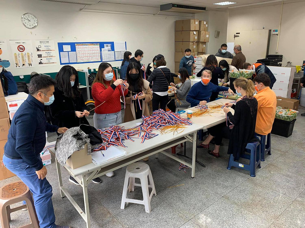 辦事處代表及同仁親手將鬱金香綁上荷蘭國旗三色的緞帶和特製卡片。 圖：取自荷蘭貿易暨投資辦事處Facebook