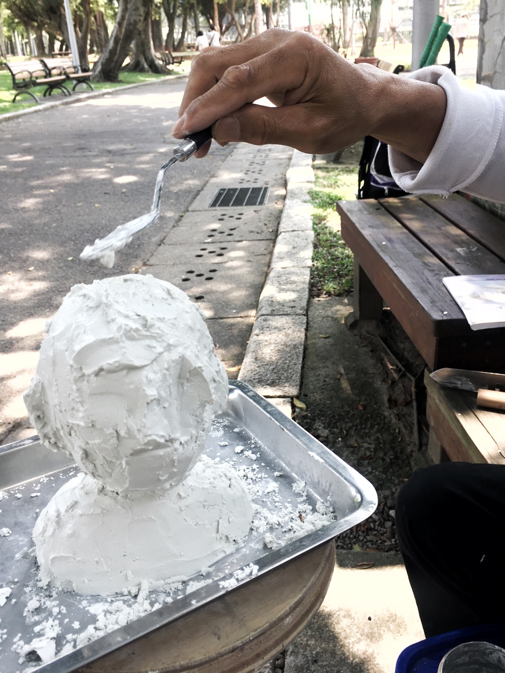 趙再添用白色水泥一刀一刀刻畫他所欣賞的人物。他正在為鴻海創辦人郭台銘雕塑頭像。 圖：張良一/攝