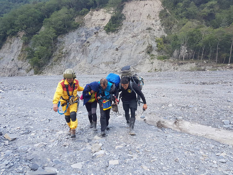 南投縣消防局3日獲報，一支台中的自組登山隊欲縱走能高安東軍，但一名40多歲女隊員（左2）卻因跌倒造成額頭大範圍撕裂傷，且有嘔吐情形，無法行走，空勤直升機4日出動救援，協助傷者送醫。 圖 : 南投縣消防局/提供