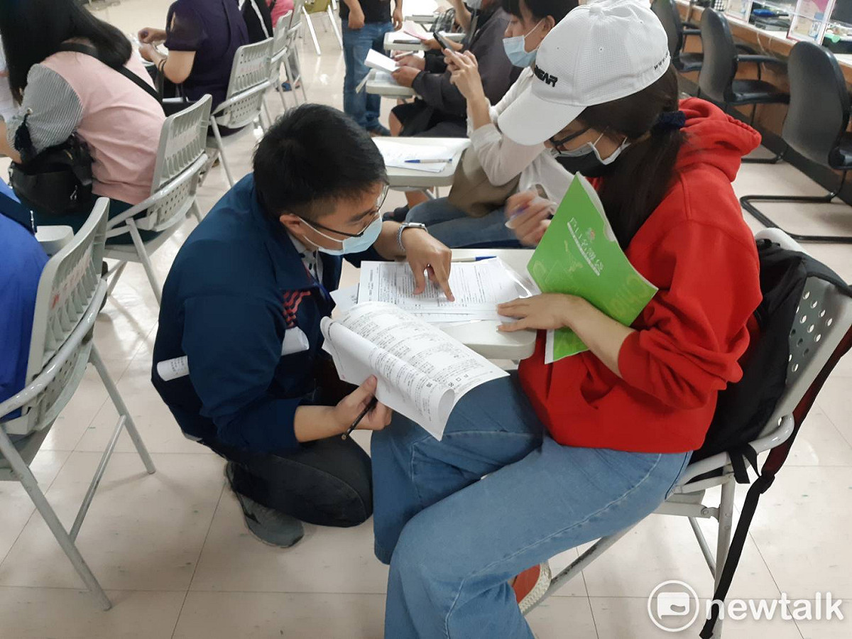 嘉義市東區區公所人員耐心向民眾說明如何申請擴大紓困方案。 圖：蔡坤龍/攝