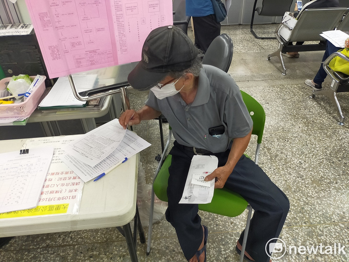 市民看著密密麻麻的申請表，不知從何填起。 唐復年/攝