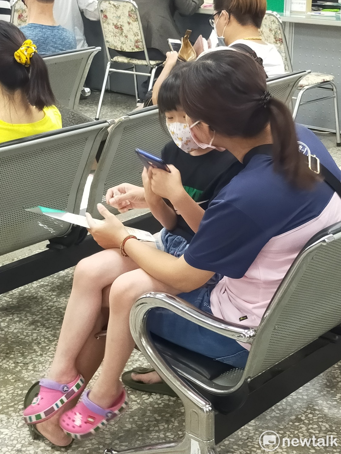 媽媽帶著小孩等著申請紓困方案。 唐復年/攝