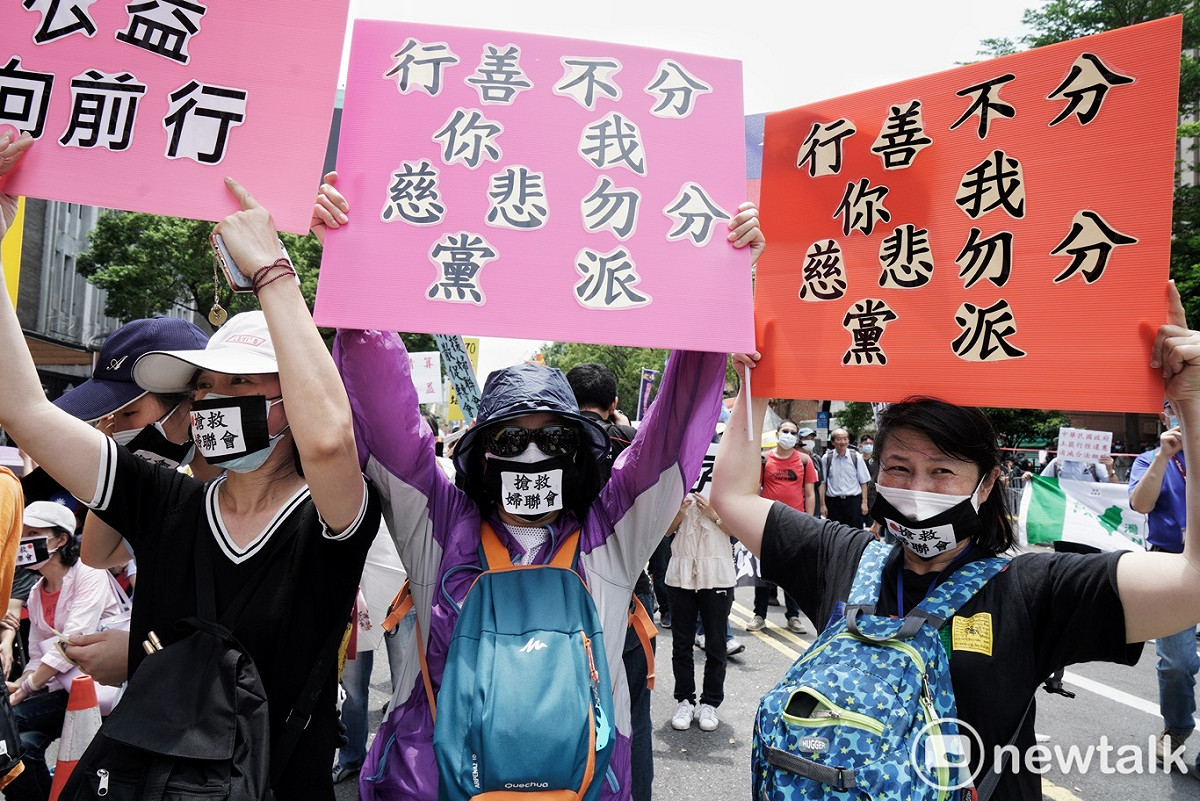 多位民眾戴著「搶救婦聯會」黑色口罩，並高舉牌子聲援婦聯會。 圖：張良一/攝