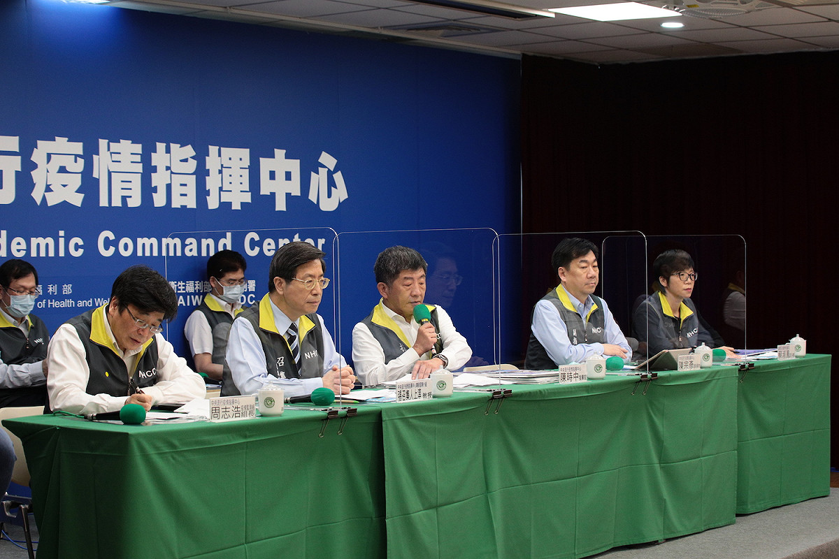 指揮中心今（12）日全員取下口罩，座位間加設隔板。 圖：截自中央流行疫情指揮中心直播影片