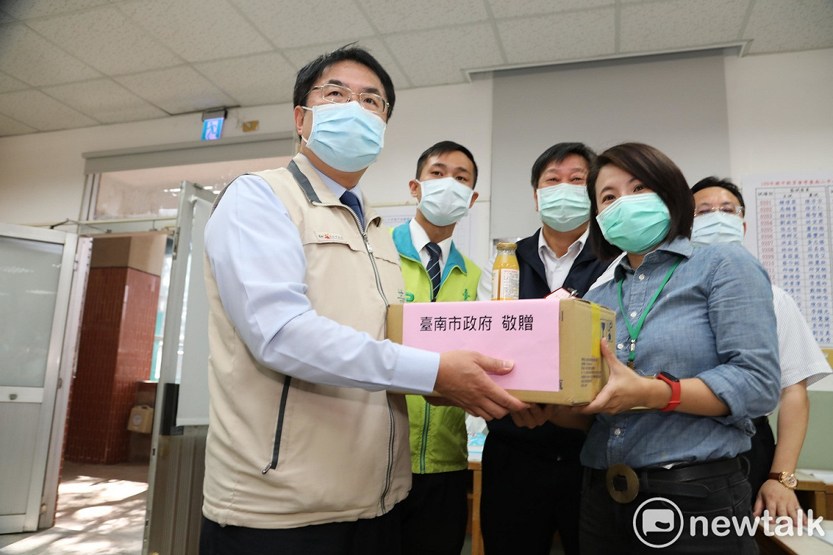台南市長黃偉哲一早前往國中會考主辦學校台南二中，為考生加油打氣，並贈送鳳梨汁慰勉現場試務工作人員的辛苦。 圖：黃博郎／攝
