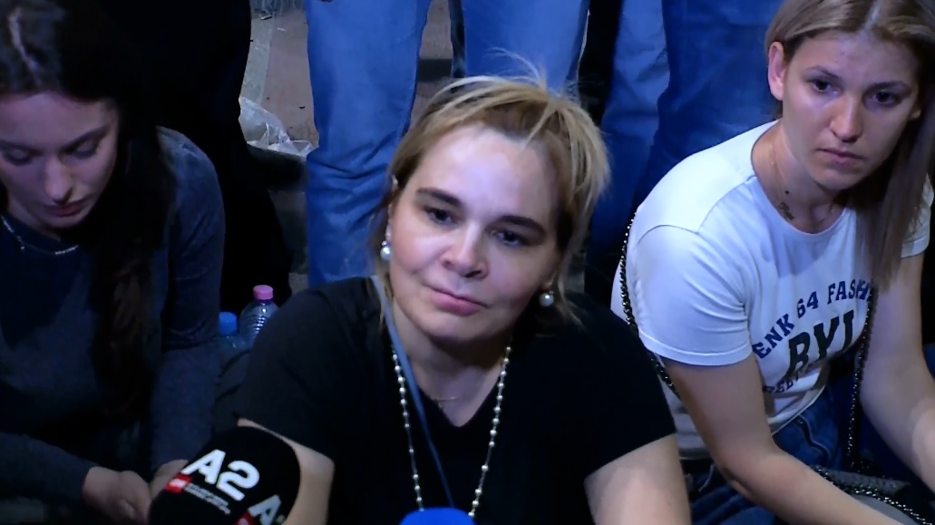 阿爾巴尼亞第一夫人克芮艾瑪迪（中）龐克打扮，坐在首都國家劇院前，準備抗議總理拆除行動前受訪，後來被帶上警車。 圖：翻攝自克芮艾瑪迪臉書影片
