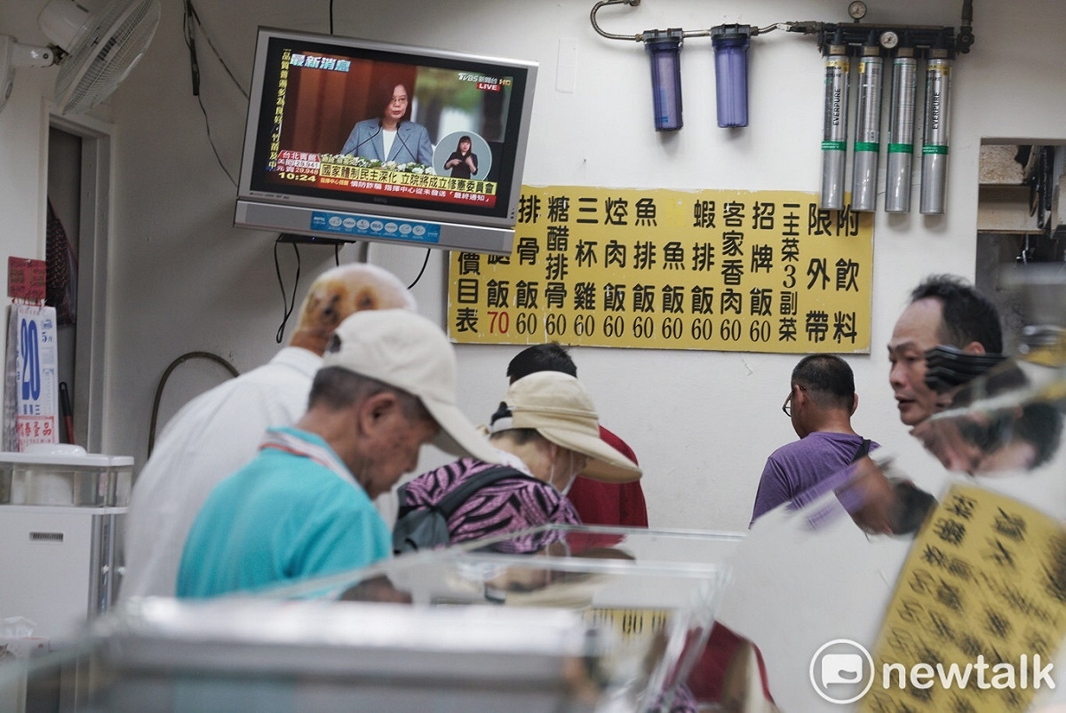 餐廳的電視正播放著蔡英文演說，民眾如常安靜吃飯。 圖：張良一／攝