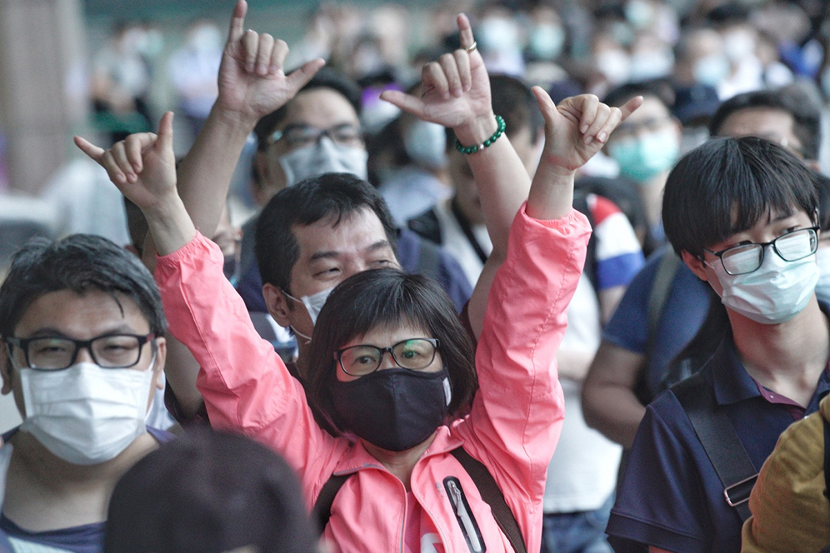 排隊等著領罷韓布條的民眾高舉6月6日罷韓的手勢，展現罷韓決心。 圖：張良一/攝