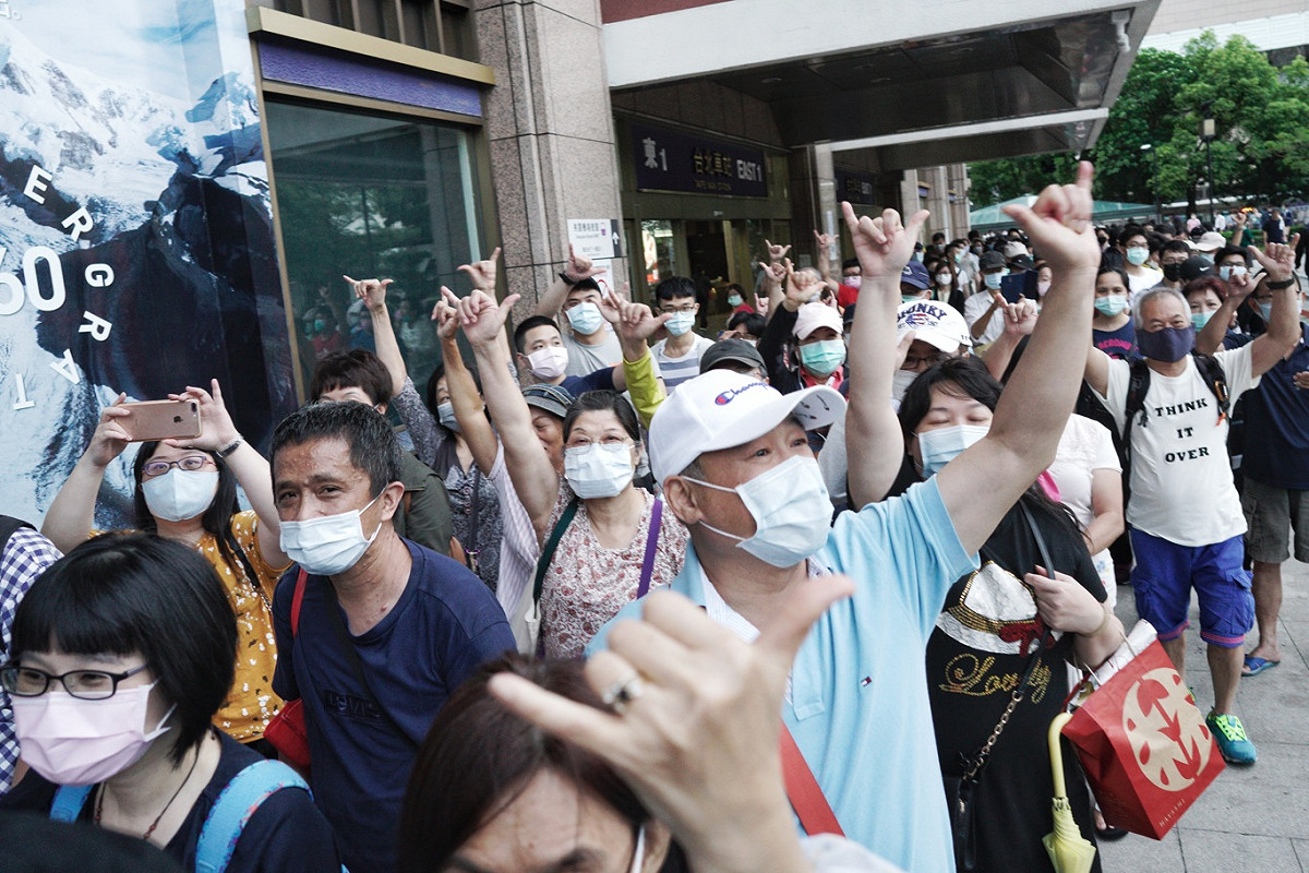排隊等著領罷韓布條的民眾高舉6月6日罷韓的手勢。 圖：張良一/攝