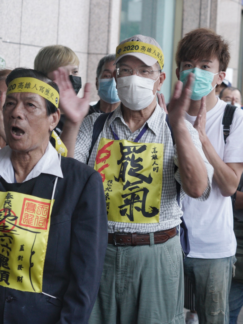 一位高雄旅北民眾將一張「高雄人的罷氣」標語貼在胸前，等著領取罷韓布條。 圖：張良一/攝