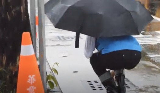 韓國瑜視察時特別蹲低近看水溝排水情形。 圖：高雄市政府提供