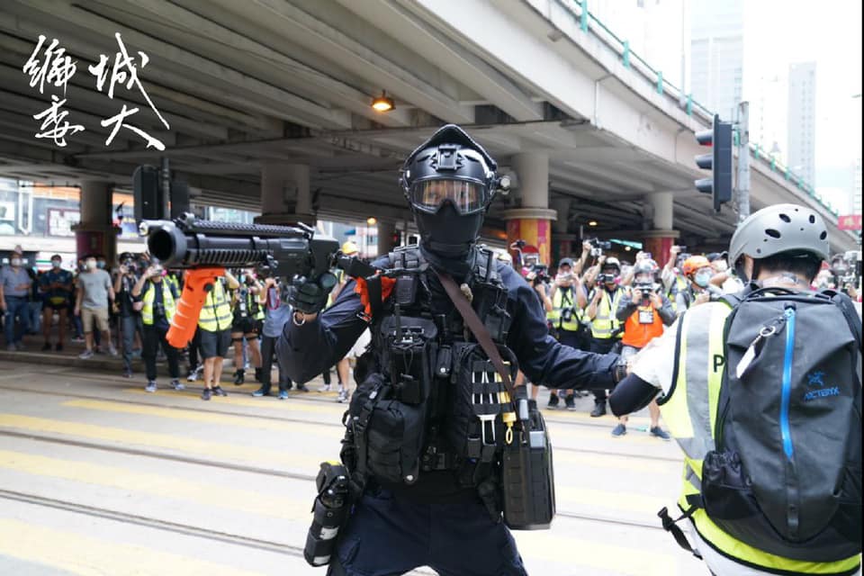 有一名警員以胡椒球槍近距離直指在場記者，但記者群身後的市民早已散開。 圖：翻攝自香港城市大學學生會編輯委員會