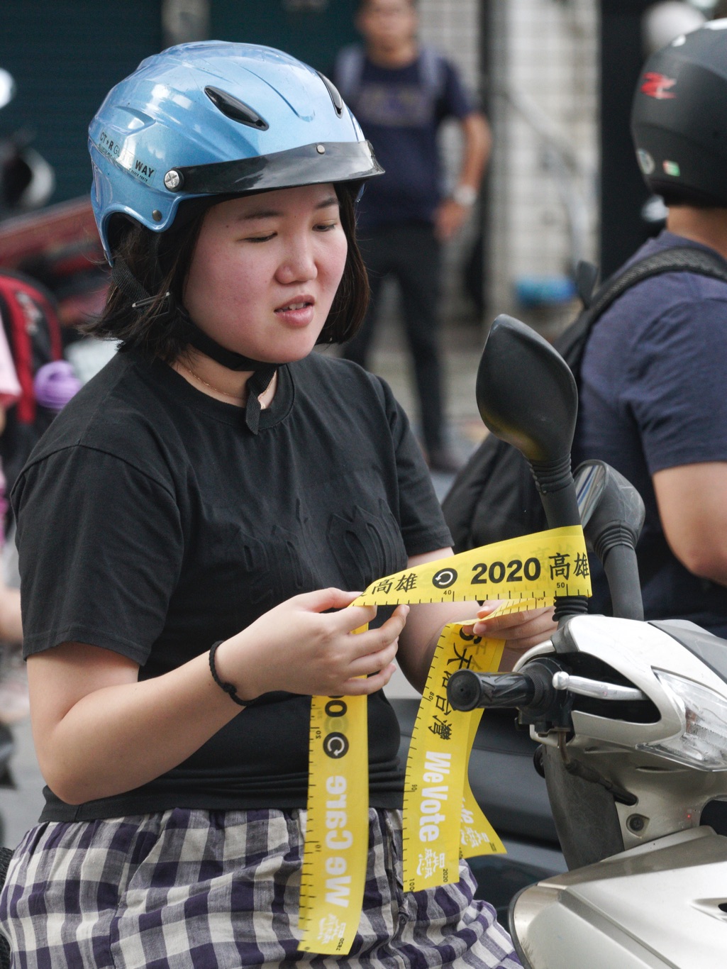 一位女騎士將罷韓黃絲帶綁在機車的後視鏡上。 圖：張良一/攝