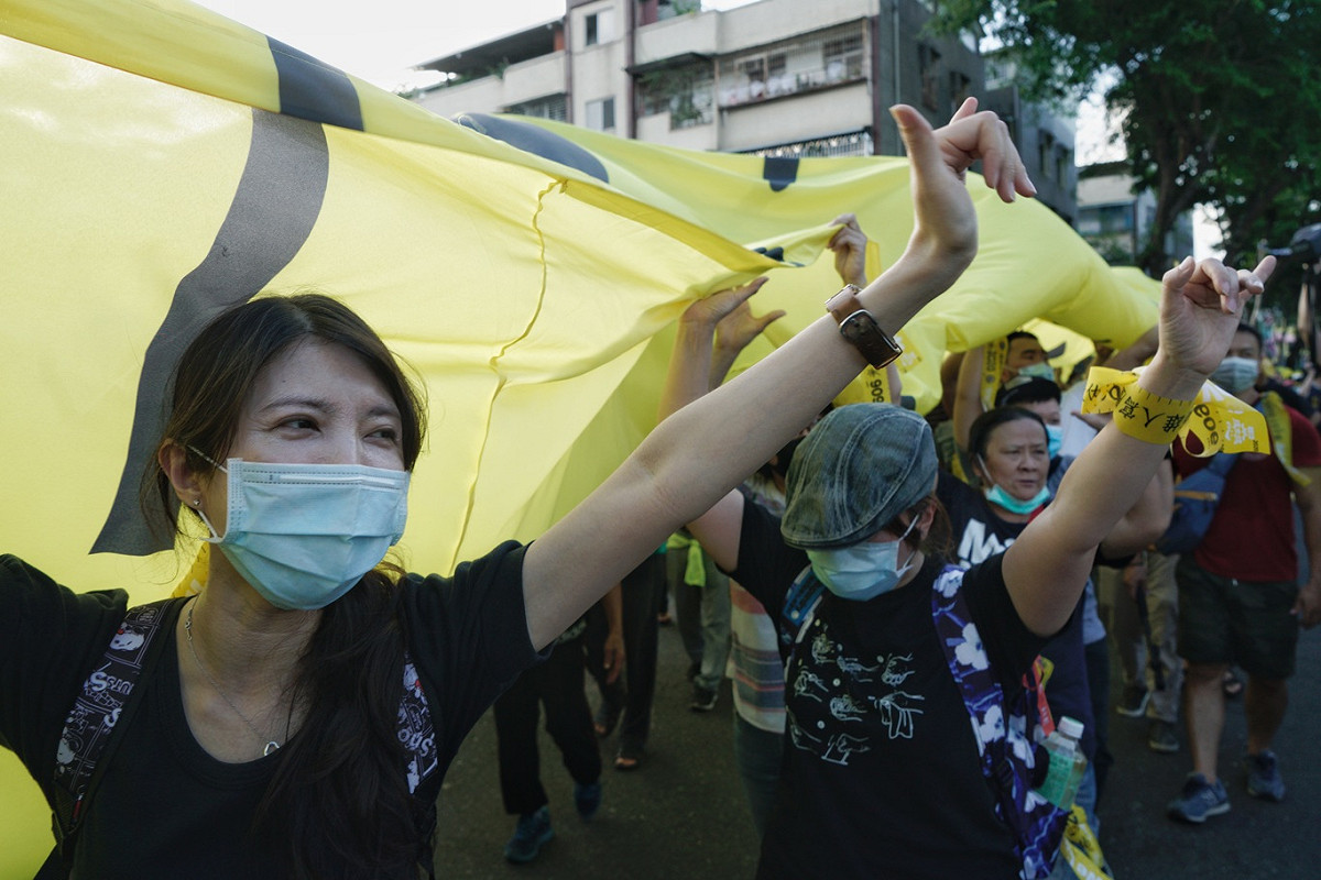 參加罷韓三山演習的民眾向過往路人比出罷韓手勢。 圖：張良一/攝