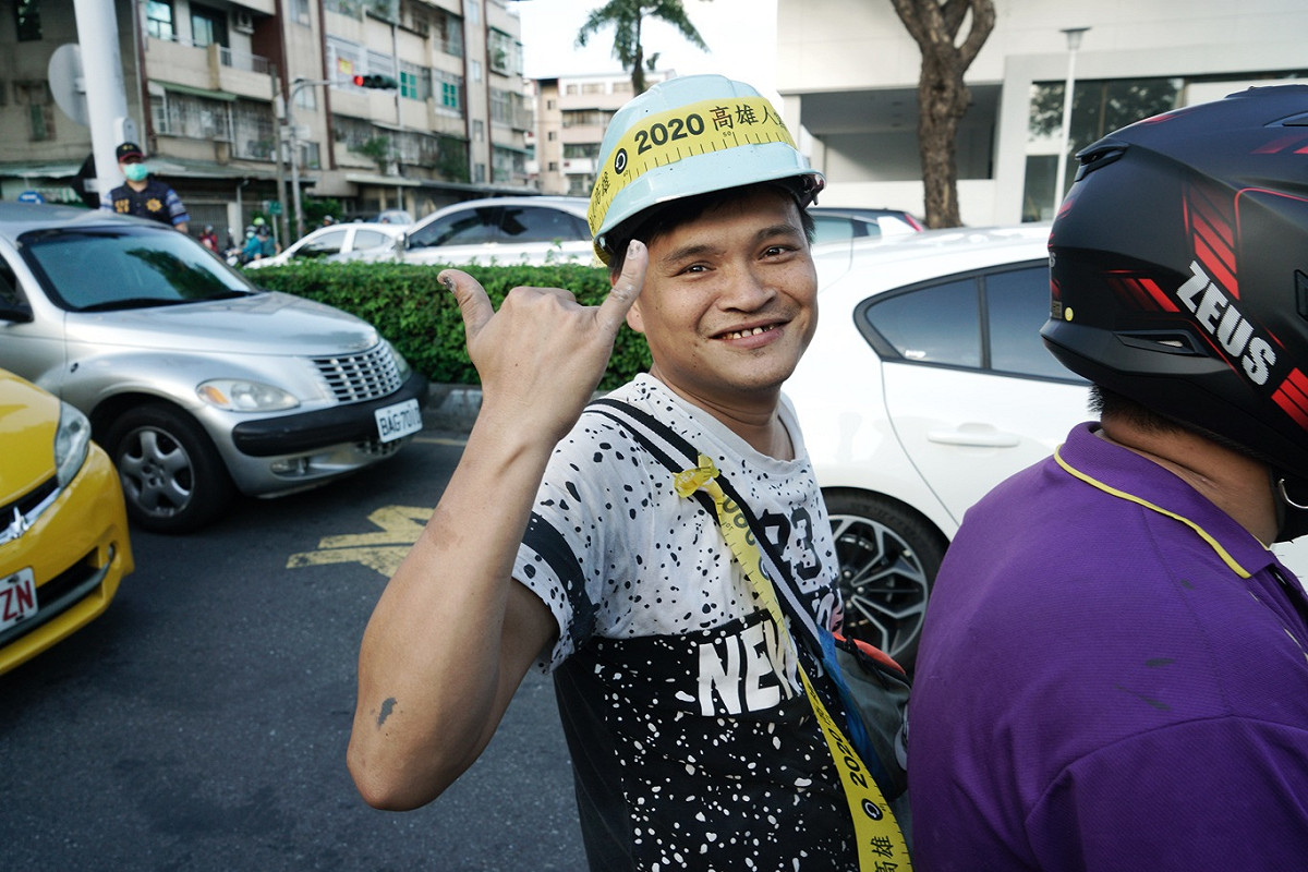 一位機車騎士向參加罷韓三山演習的民眾比出罷韓手勢。 圖：張良一/攝