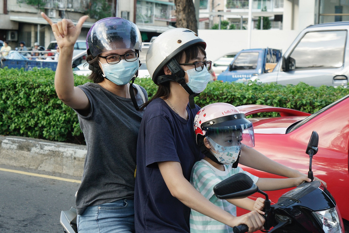 一位機車騎士向參加罷韓三山演習的民眾比出罷韓手勢。 圖：張良一/攝