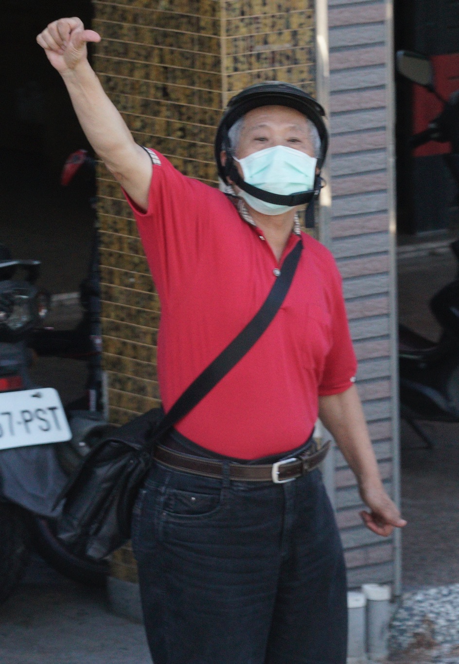 一位高雄市民對著罷韓掃街車隊機動的倒比姆指。 圖：張良一/攝